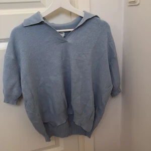 Ljusblå tröja från Stories - Säljer en ljusblå tröja från Stories i storlek M. Tröjan har en v-ringad design med krage och trekvartsärmar. Perfekt för en avslappnad stil. 💙