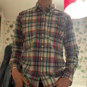 Rutig skjorta från Polo Ralph Lauren - Säljer en klassisk rutig skjorta från Polo Ralph Lauren i storlek M. Skjortan har en mångfärgad design med inslag av rött, grönt, blått och vitt. Priset är inte slaget i sten.                                    Kolla in profilen för liknande plagg