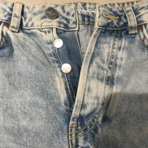 Ljusblå jeans med slitningar från Never Denim - Snygga ljusblå jeans från never Denim med slitningar på benen. Högmidjade. Uppklippta nertill. Sitter jättebra, tyvärr växt ur:/