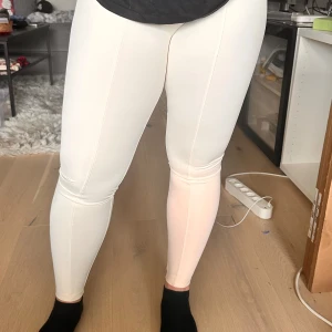 Vita leggings - Säljer ett par vita leggings med hög midja och tight passform. De är helt släta utan synliga detaljer och passar perfekt till både träning och vardagsoutfits. Materialet känns mjukt och stretchigt.