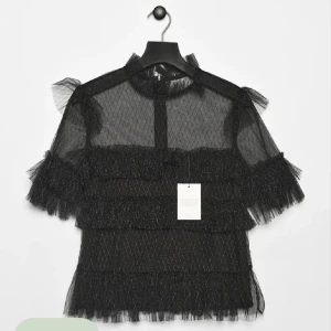 By Malina blus - Säljer min fina och populära svarta blus ifrån By Malina. Den är svart med glittriga detaljer och flera lager volanger. Perfekt för dig som vill sticka ut med en trendig och elegant look. Knappt använd, nypris är 1600kr. OBS de tre första bilderna är lånade, min har ej någon lapp kvar!! Hör av dig vid frågor💗