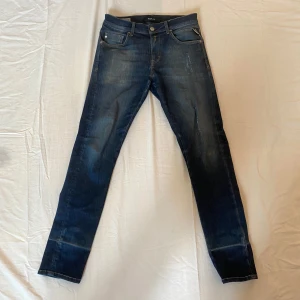 Mörkblå Replay jeansbyxor - Säljer ett par mörkblå jeans från Replay i storlek 29. Dom är i ett användt skick men några defekter som gör brallorna riktigt feta. 