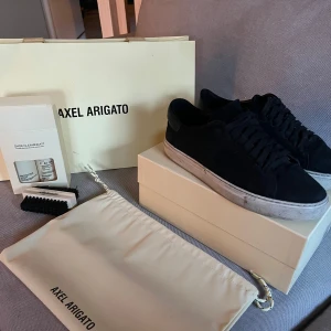 Svarta sneakers från Axel Arigato - Säljer ett par svarta sneakers från Axel Arigato med vit sula. Kommer med originalpåse, skokartong och rengöringskit. Perfekta för en stilren vardagslook. Köpta för 3000. Mitt pris 899. Skorna är ganska använda men man får med shoe cleaning kit så det går att hålla dom fräscha🤩