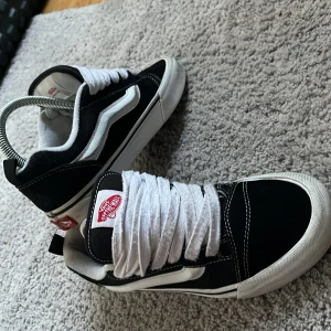 Svarta och vita Vans Old Skool sneakers - Klassiska Vans Old Skool sneakers i svart och vitt med vit sula och vit sidosnöre. Skorna har tjocka vita skosnören och den ikoniska vågformen på sidan. Perfekta för en streetwear-look och passar till det mesta. Dem är storlek 37 men kan även användas om man har storlek 39. Dessa skor är perfekta för sommaren då man vill vara ute med vännerna och umgås. 