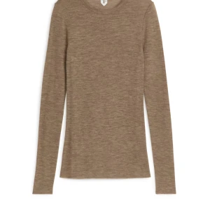 ARKET-LÅNGÄRMAD TOPP I MERINOULL   - En topp i mjuk merinoull från Arket. Figurnära passform och lätt genomskinlig. Råa kanter vid ärmslut och i nederkant. Av 100 % RWS-ull . Använd 1 gång, absolut inga spår av användning. Nypris: 570kr