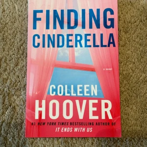 Finding Cinderella (oanvänd) - Säljer boken 'Finding Cinderella' av Colleen Hoover. Omslaget är rosa med blå och vita detaljer och motiv av ett fönster med gardiner. Boken är en romantisk ungdomsroman och är en del av Hopeless-serien. Perfekt för dig som gillar kärlek och drama.