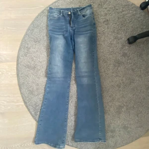 Blå bootcut jeans med dekorerade bakfickor - Säljer ett par blåa bootcut jeans med snygga broderier på baksidan💓 Nyskick, 300kr nya😊Står ej storlek men passar mig som är 171cm
