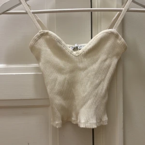 Topp från Zara  - Snygg croppad topp från zara. Är i storlek s men passar mig som har xs. Toppen har en liten svart fläck som knappt syns(se på andra bilden) men som säkert försvinner i tvätten.