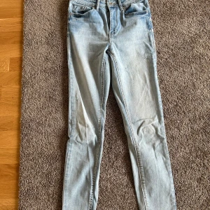 Ljusblå skinny jeans - Säljer ett par ljusblå skinny jeans med klassisk femficksdesign och normalhög midja. Jeansen har en smal passform och är perfekta för en avslappnad stil. Passar till det mesta och är lätta att matcha med olika toppar.