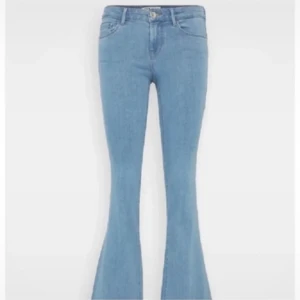 Ljusblå bootcut jeans från ONLY - Säljer ett par ljusblå bootcut jeans från ONLY. Jeansen har klassisk femficksdesign, normal passform upptill och utsvängda ben. Tillverkade i mjuk denim med knapp och dragkedja framtill.