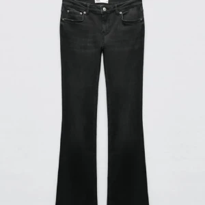 Svarta bootcut jeans - Snygga svarta bootcut jeans med klassisk femficksdesign och knappgylf. Jeansen har en något utsvängd passform nertill och sitter tajt upptill. Perfekta för dig som vill ha en stilren och tidlös look.
