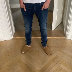 Replay Hyperflex Anbass jeans herr - Säljer ett par mörkblå Replay Hyperflex Anbass jeans med slim fit. Klassisk femficksmodell med snygga slitningar och vita sömmar. Stretchigt material för extra komfort. Perfekta för dig som gillar ett moderna par jeans. Säljer för 700, nypris 1700. Sällan använda och väldigt bra skick. Size 32. Mannen på. Bilden är 185. Kan ändra pris vid snabbt köp.