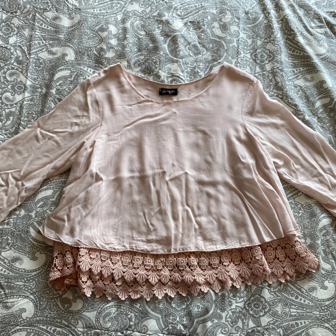 Ljusrosa blus med spetsdetalj