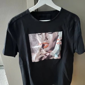 Svart t-shirt med tryck från Limitato - Svart t-shirt från Limitato med ett coolt tryck, prefekt inför sommarn. Klassisk rund halsringning och korta ärmar i storlek L. 