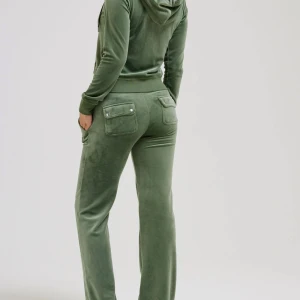 juicy couture set (pris kan diskuteras) - Juicy Couture set i färgen grön. Storlek XXS på både koftan och byxan. Är i bra skick, använts ett antal par gånger. Har ett litet skada på knät men inget hål bara materialet som förstörts lite, även metall grejerna på snörerna på byxan e borta.