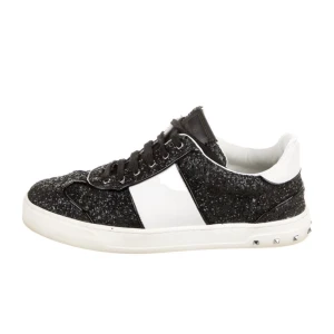 Valentino flycrew Svarta och vita sneakers med glitter och nitar från Valentino - Säljer ett par snygga sneakers från Valentino i svart och vitt med glittrig ovandel och coola nitar på sulan. Skorna har snörning och en klassisk rund tå. Perfekta för dig som vill sticka ut med din stil.