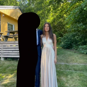 Champagnefärgad långklänning med v-ringning - Säljer min balklänning! Champagnefärgad super fin och väldigt lång, går nog enkelt att sy upp ifall man skulle vilja