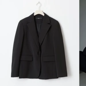 svart blazer  - Stilren svart kavaj från Gina Tricot, endast använd 1 gång så i princip ny! Kavajen har en enkelknäppning och rak passform, perfekt för en snygg och tidlös loo, passar t allt!