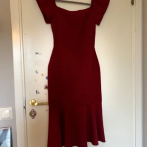 Vinröd klänning med volang från Trendyol - Säljer en vinröd klänning från Trendyol i storlek 34. Klänningen har offshoulder-modell, figurnära passform och en volang nertill. Perfekt för festliga tillfällen och har en elegant siluett.