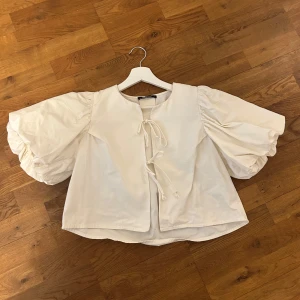 Vit blus med puffärmar och knytning - Säljer en vit blus från ginatricot, med stora puffärmar och knytning framtill. Använd fåtal gånger!