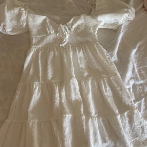 Klänning - Vit fin klänning, endast använd en gång, så är i nyskick. Perfekt till student, avslutning, konfirmation mm. Skicka vid intresse eller om ni vill se den på!