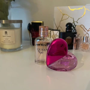 La Rive Queen of Life Eau de Parfum och rosa hjärtformad parfymflaska - Säljer en La Rive Queen of Life Eau de Parfum i genomskinlig flaska med guldlock samt en rosa, hjärtformad parfymflaska. Perfekt för dig som gillar söta och eleganta dofter. Flaskorna är snygga att ha framme på sminkbordet.