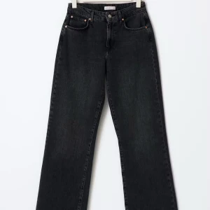 Svarta wide jeans - Säljer ett par svarta jeansbyxor med rak passform och medel hög midja. Jeansen har klassisk femficksdesign och stängs med knapp och dragkedja. Perfekta till både sneakers och klackar för en stilren look. Jeansen är använda typ 2 gånger utan några synliga tecken. Köpta för 500kr. 