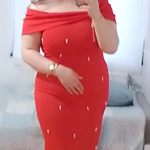 Röd offshoulder klänning med pärldetaljer - Säljer en röd, figurnära offshoulder klänning med små pärldetaljer. Klänningen har en elegant axelbandslös design och är i stretchigt material som framhäver siluetten. Perfekt för dig som vill sticka ut med en färgstark look.