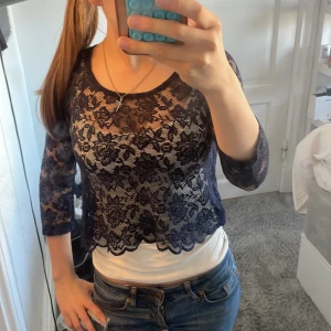 Mörkblå spetsblus från Gina Tricot - Säljer en skitsnygg mörkblå, genomskinlig spetsblus från Gina Tricot. Blusen har trekvartsärm och blommig spets med vågig kant nertill. Perfekt att styla över ett linne eller topp nu till sommaren! Aldrig använt 💕