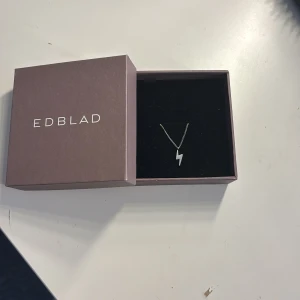 Silverhalsband med blixt från Edblad - Säljer ett stilrent silverhalsband från Edblad med ett blixtformat hänge. Kedjan är tunn och elegant, perfekt för att ge en cool touch till din outfit. Levereras i originalask. Nypris 299kr mitt pris 100kr💗 