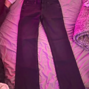 Svarta bootcut jeans från Lee Jessica - Säljer ett par svarta Lee Jessica jeans med bootcut och låg midja. Jeansen har klassisk femficksdesign. Dom är helt nya endast provade då jag fick dom i present och det var fel storlek, kunde tyvärr inte skicka tillbaka. Storleken är 29/33 så skulle säga att dom passar en S/M. Priset är inte hugget i sten och de är bara att skriva om ni har några frågor!