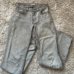 Grå jeans Gina  - Snygga grå jeans, de har en rak passform, modellen ”low straight jeans” från Gina. Säljer då de är för stora för mig! De är lite trampade på där bak och har även klippt upp sömmen där nere för att de skulle bli längre 
