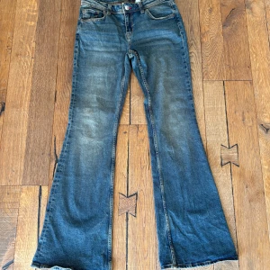 Blå bootcut jeans - Säljer ett par klassiska blå bootcut jeans med lätt slitning framtill. Jeansen är lågmidjade  och vida ben nertill! Frakt ingår ej ❤️