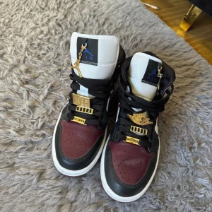 Nike Air Jordan 1 Beetroot  - Säljer ett par Nike Air Jordans med guldiga smycken, limited edition. Säljer pga för små, använda ksk max 2 gånger.