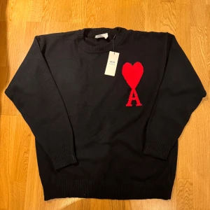Svart stickad tröja från Ami med rött hjärta - Svart stickad tröja från Ami med ett stort rött hjärta och bokstaven A på bröstet. Tröjan har rund halsringning och ribbade muddar vid ärmslut och nederkant. Perfekt för dig som gillar stilrena plagg med en twist. Helt ny och inte använd. Ny pris 4500kr| mitt pris 700. Skriv om ni har frågor, priset går alltid att diskutera! ❤️