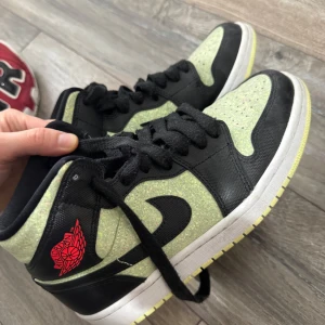 Nike Air Jordans i svart och ljusgrön - Säljer ett par Nike Air Jordans med svart och ljusgrön färgkombination. Skorna har svarta snören, svart swoosh och röd Air Jordan-logga på sidan. Klassisk hög modell med perforerad tå och vit sula. Pris går att diskutera