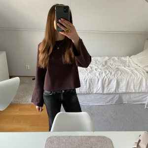 Brun stickad tröja med vida ärmar - Säljer en stickad croppad tröja med rund hals och långa, vida ärmar. Tröjan har en enkel och stilren design, perfekt att matcha med jeans eller kjol. Materialet känns mjukt och kliar inte mot huden.
