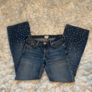Mörkblå jeans med pärldetaljer - Säljer ett par mörkblå lågmidjade bootcut jeans med snygga pärldetaljer nertill. Jätte bra ackord i storlek 26💗 skriv för fler bilder eller mått 