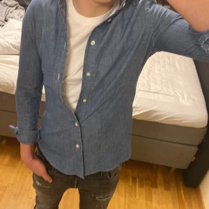 Polo Ralph Lauren skjorta  - Tjena! Säljer denna blåa Ralph lauren skjorta i storlek 2 som är som XS Skjortan är i modellen custom fit men sitter mer som slim fit. Skjortan har inga defekter och skicket är 8/10, jag på bilden är 174 och väger 62kg. Sömmarna på ryggen är lite uttöjda vilket man kan se på bilderna. Tveka inte med att kontakta mig om du har några frågor. 