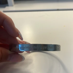 Silverfärgat armband med gravyr - Stilrent armband i silverfärg med texten 'Be a giver, not a getter' ingraverat. På sidan finns ett litet hjärta som detalj. Perfekt accessoar för dig som gillar enkla men meningsfulla smycken.