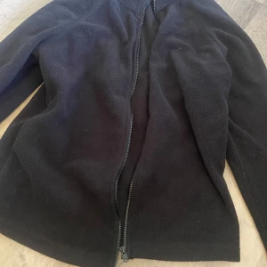 Svart fleecejacka från SHEIN XS - Mysig svart fleecejacka från SHEIN i storlek XS. Jackan har dragkedja framtill och är tillverkad i mjukt fleecematerial som håller dig varm. Perfekt för kyliga dagar och enkel att matcha med allt.