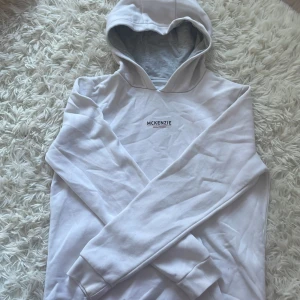 Vit hoodie från McKenzie med tryck - Snygg vit hoodie från McKenzie med stilrent tryck på bröstet. Klassisk huva och långa ärmar, perfekt för en chill och avslappnad look. Mjuk och skön bomullsmix som passar året runt. Enkel att matcha med jeans eller joggers.