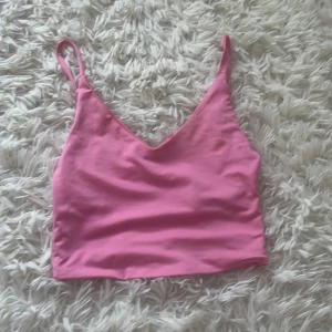 Rosa linnetopp från Amisu XXS - Supersöt rosa linnetopp från Amisu i storlek XXS. Toppen har smala justerbara axelband och v-ringad halsringning. Perfekt för varma dagar och enkel att matcha med jeans eller kjol. Materialet är mjukt och stretchigt för en bekväm passform.