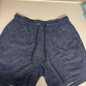 Mörkblå mjuka shorts med snörning - Snygga mörkblå shorts i mjukt material med dragsko i midjan. Perfekta för chill dagar eller träning. De har en relaxed fit och är riktigt bekväma att ha på sig.