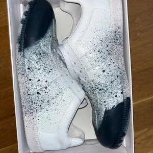 Maison Margiela skor - Färg = vit med marinblå splatter på. Storlek 46. Riktigt bekväma aldrig använda bara test använda, skick och material 10/10 verkligen. Box med. OBS = ej äkta 1;1. Det är bara att fråga om pris eller fler bilder
