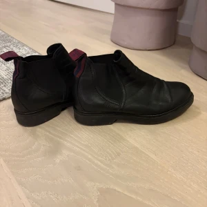Svarta boots från Dasia - Svarta chelsea boots från Dasia i skinn med elastiska paneler på sidorna och dragflikar bak. Klassisk rund tå och robust sula som ger bra grepp. Perfekta för dig som vill ha en stilren och tidlös look till höst och vinter. Mycket bra skick