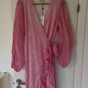 Rosa  omlottklänning Dry Lake - Supersöt rosa omlottklänning från Dry Lake med knyt i midjan. Helt ny med prislappen kvar och aldrig använd. 