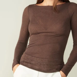 Brun långärmad topp intimissimi - Slimmad brun långärmad topp med rund halsringning. Tillverkad i tunn och mjuk bomull som sitter tight mot kroppen. Perfekt att styla med jeans eller kjol för en clean och enkel look.Intimissimi. 380kr plus frakt