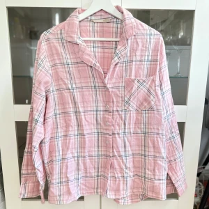 Rosa rutig pyjamas skjorta - En helt ny jättefin rosa rutig pyjamas skjorta i mjukt flanelltyg från Lager 157 i storlek M men är liten i storleken, den är mer en S. Den är i 100% bomull! FÖRST TILL KVARN!