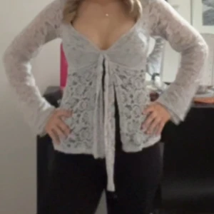 Ljusgrå spetsblus med knyt - Har ingen bra bild med tröjan på. Den är lite urtvättad men annars i bra skick. Skriv om du vill ha mer bilder eller har några frågor